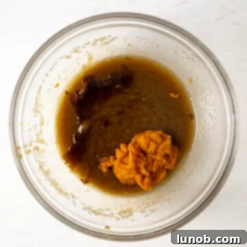 Irresistible Chewy Pumpkin Chocolate Chip Cookies 6 Wet ingredients in a bowl, with pumpkin puree and vanilla extract fully incorporated, showing a smooth, creamy texture.