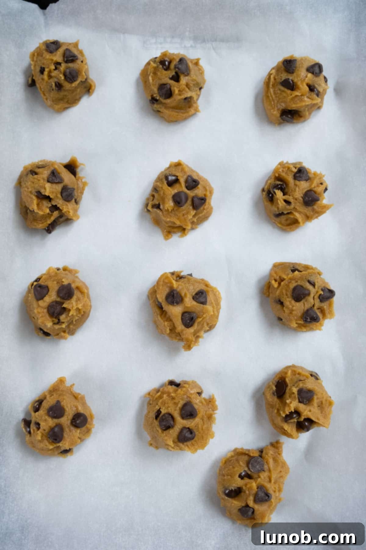 Irresistible Chewy Pumpkin Chocolate Chip Cookies 10 A tray of unbaked pumpkin chocolate chip cookie dough balls, perfectly scooped and ready for the freezer.