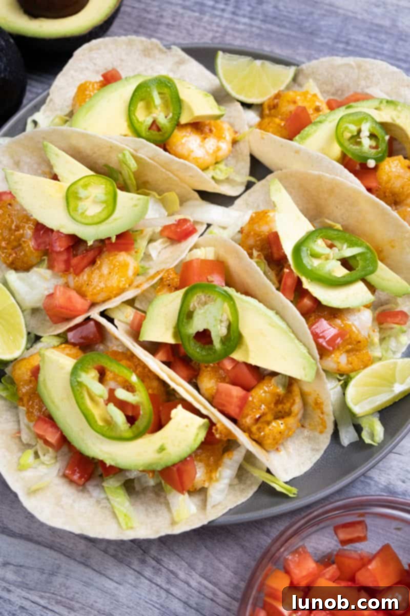 Fiery Volcano Shrimp Tacos 2 Close-up of an irresistible Volcano Shrimp Taco, showcasing the vibrant red chipotle sauce on crispy shrimp, garnished with fresh cilantro and a wedge of lime.
