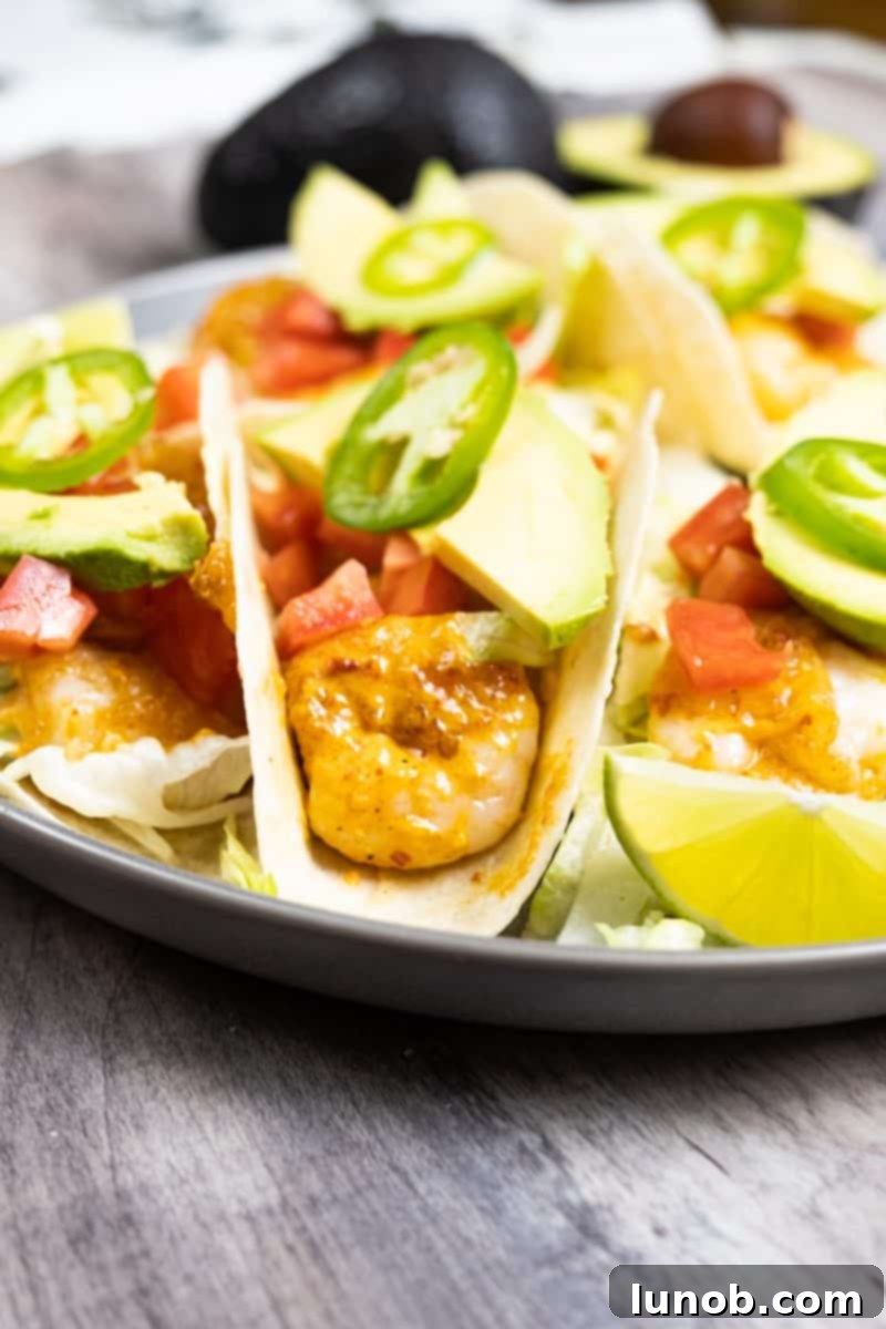 Fiery Volcano Shrimp Tacos 3 Overhead shot of two Volcano Shrimp Tacos artfully arranged on a wooden board, garnished with fresh lime wedges and vibrant herbs, ready to be enjoyed.