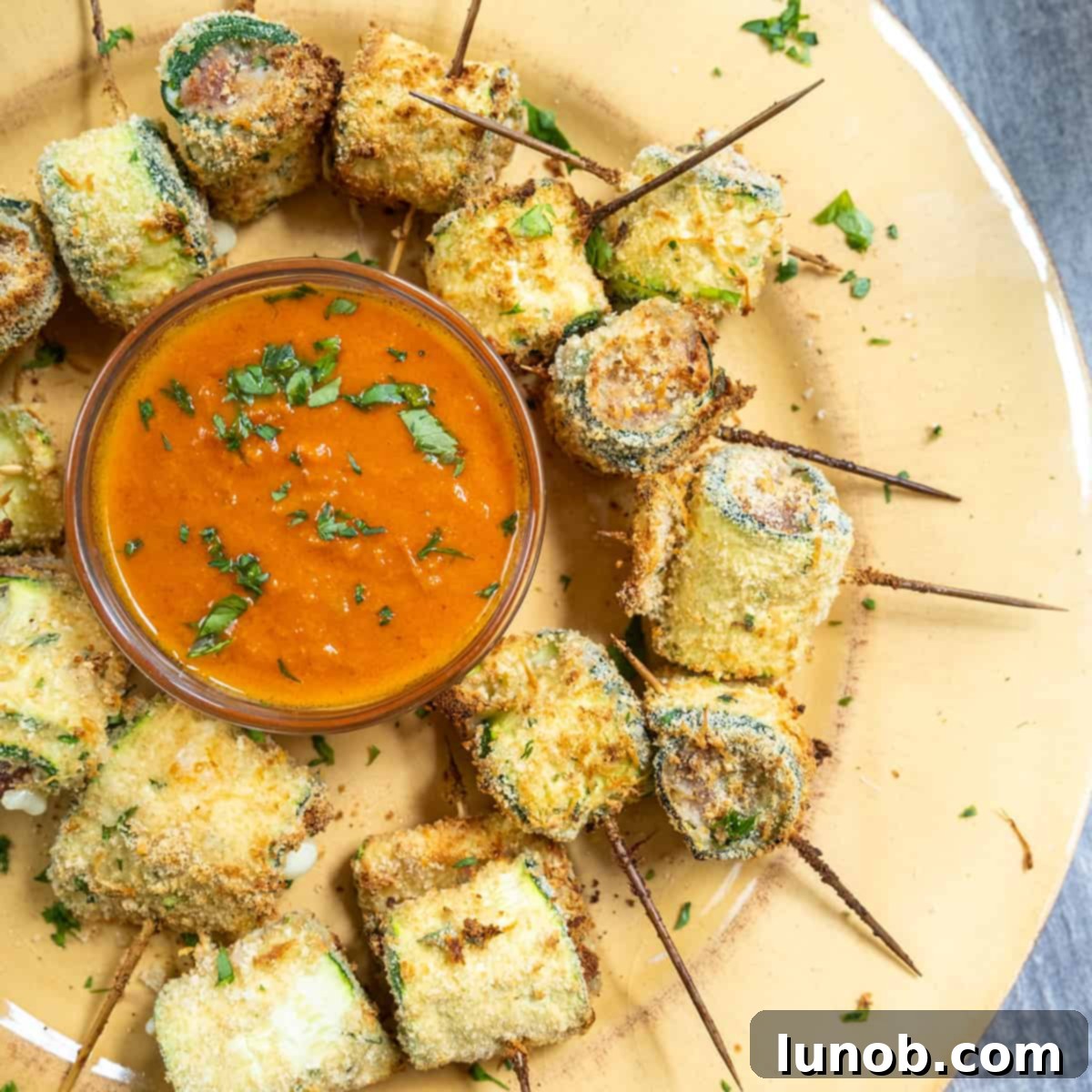 Crispy Air-Fried Zucchini Fritters 3 Air fryer zucchini rollups arranged on a plate.