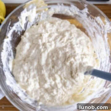 Dry ingredients mixed into the wet ingredients in a bowl with butter.
