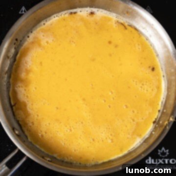 Classic Pepper & Egg Sub 9 whisked eggs in frying pan with edges beginning to curl up.