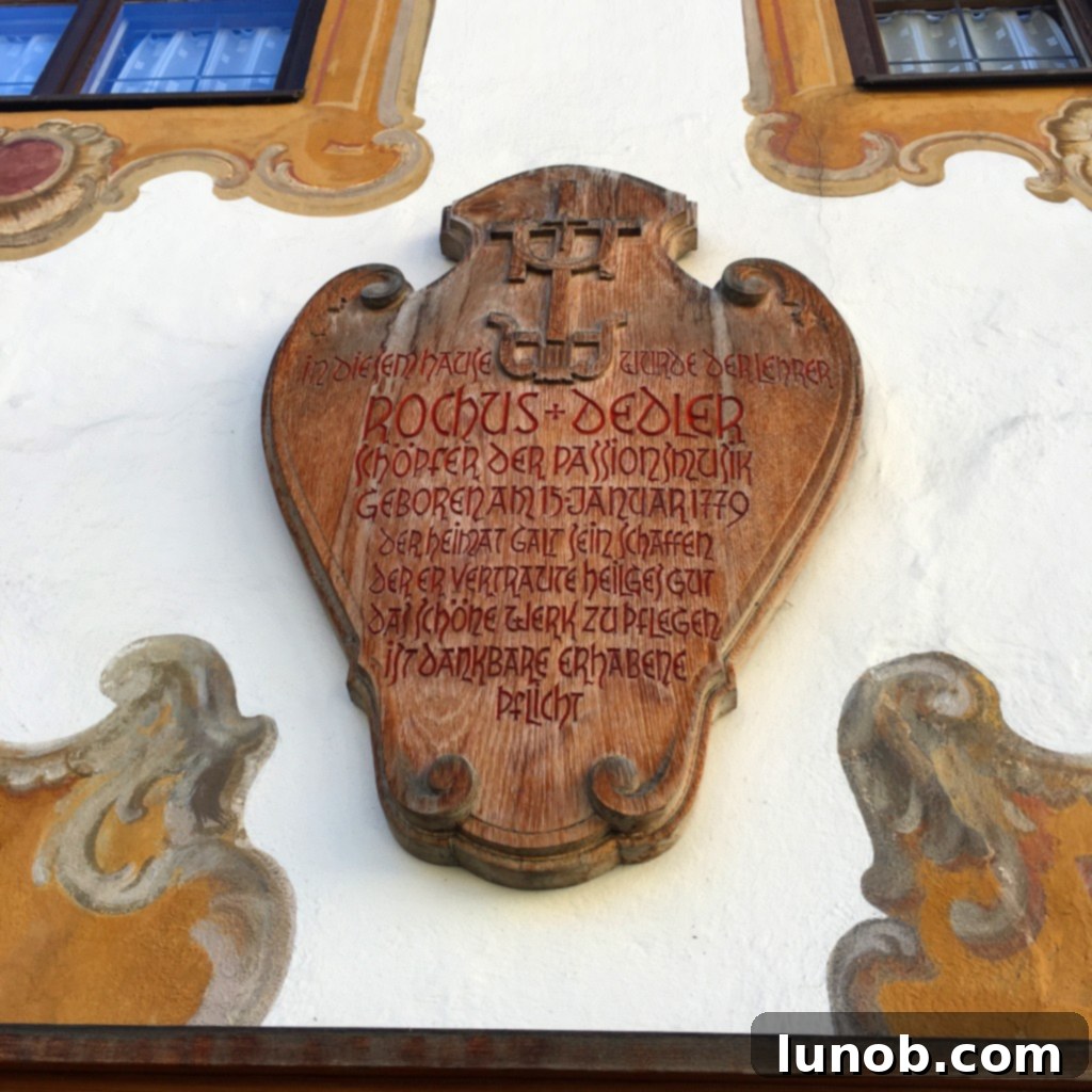 An old intricately carved wooden plaque, a piece of local artistry on a building wall in Oberammergau.