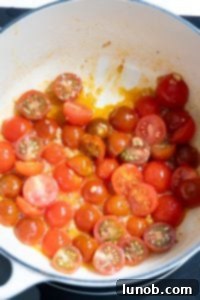 Simmering cherry tomatoes with oil and garlic