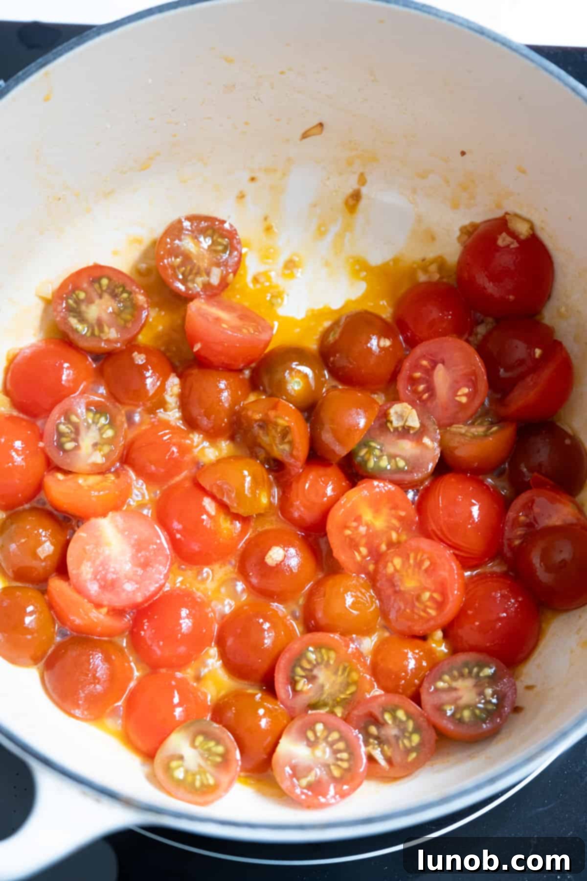 Simmering cherry tomatoes with oil and garlic