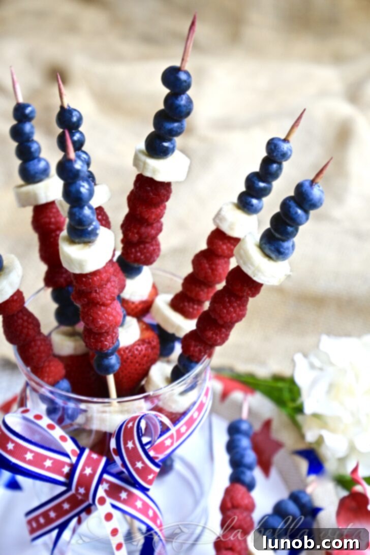 25 Red, White and Blue Recipes: Pinterest's Patriotic Stars 3 Refreshing Red, White, and Blue Fruit Kabobs on skewers, featuring strawberries, marshmallows, and blueberries.