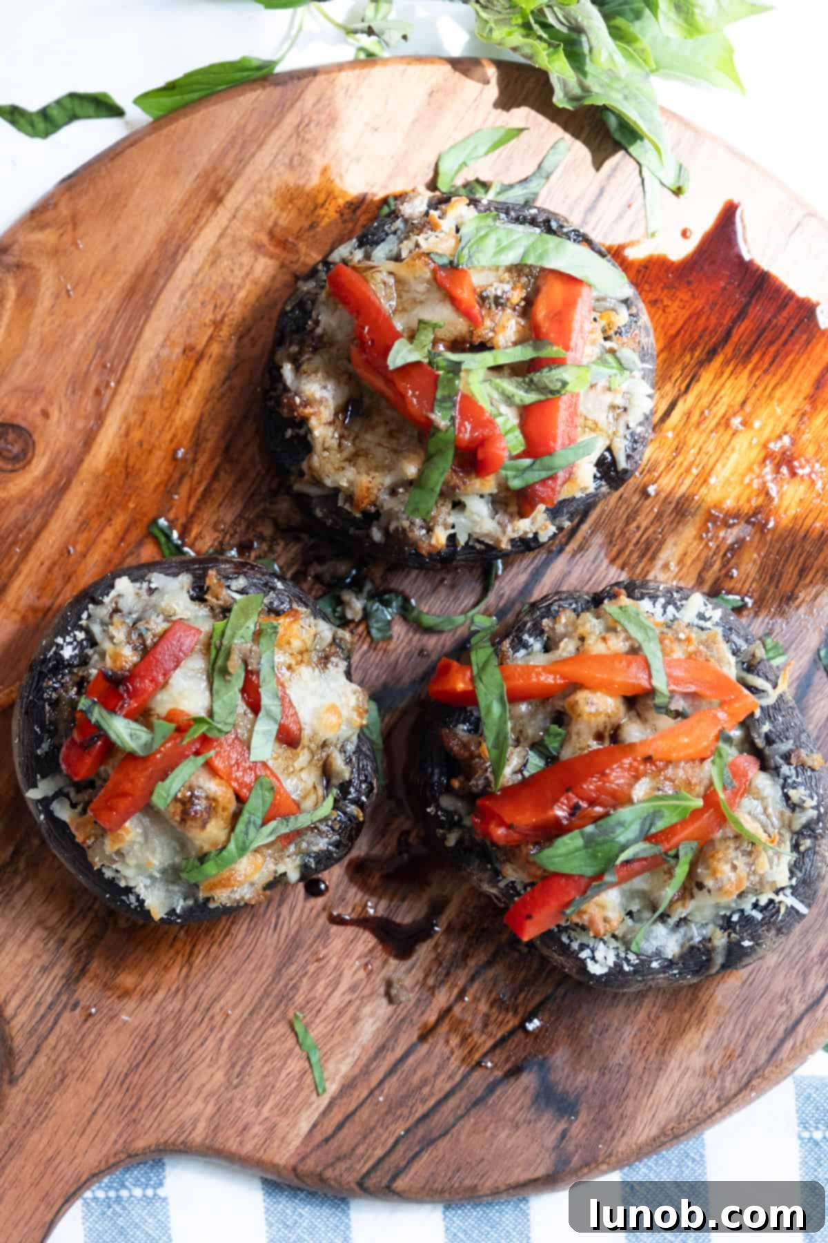 Gourmet Italian Stuffed Portobello Bake 11 finished product: mushrooms are baked and topped with red peppers, basil, and glaze.
