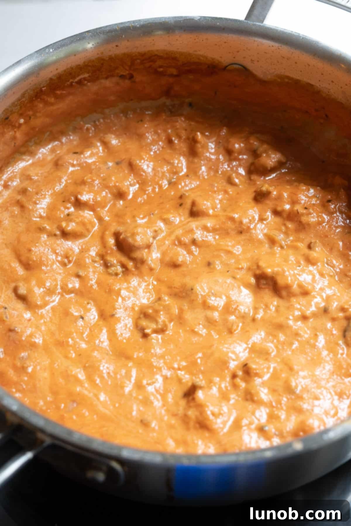 Italian pink sauce with sweet sausage warming in a large pot, ready to be tossed with pasta.