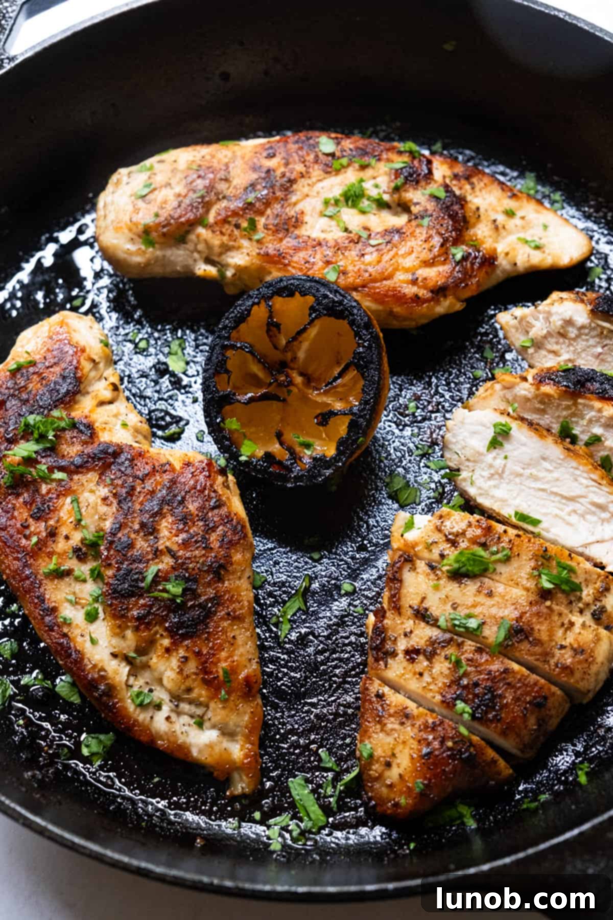 The Ultimate Cast Iron Chicken Breast 3 Fresh, uncooked cast iron chicken breast seasoned and ready to be placed in the hot skillet.