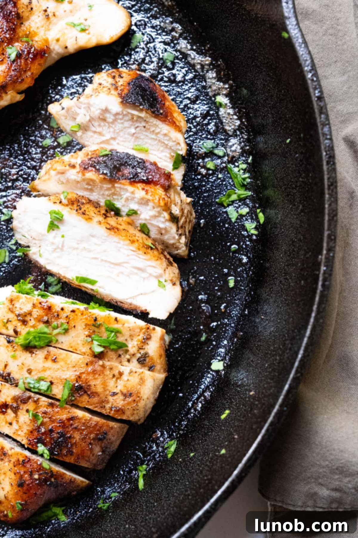 The Ultimate Cast Iron Chicken Breast 8 Perfectly sliced, juicy cast iron chicken breast fanned out on a plate, ready to be served.