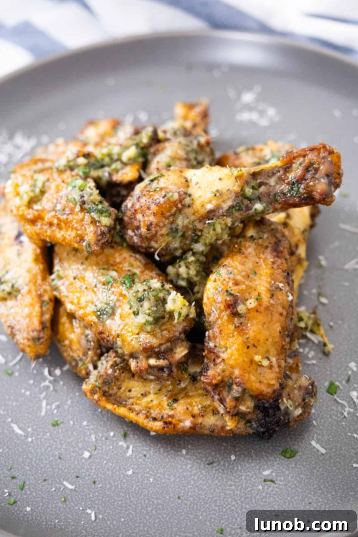 Crispy Air Fryer Garlic Parmesan Wings 2 air fryer garlic parm wings garnished with fresh parsley on a serving platter
