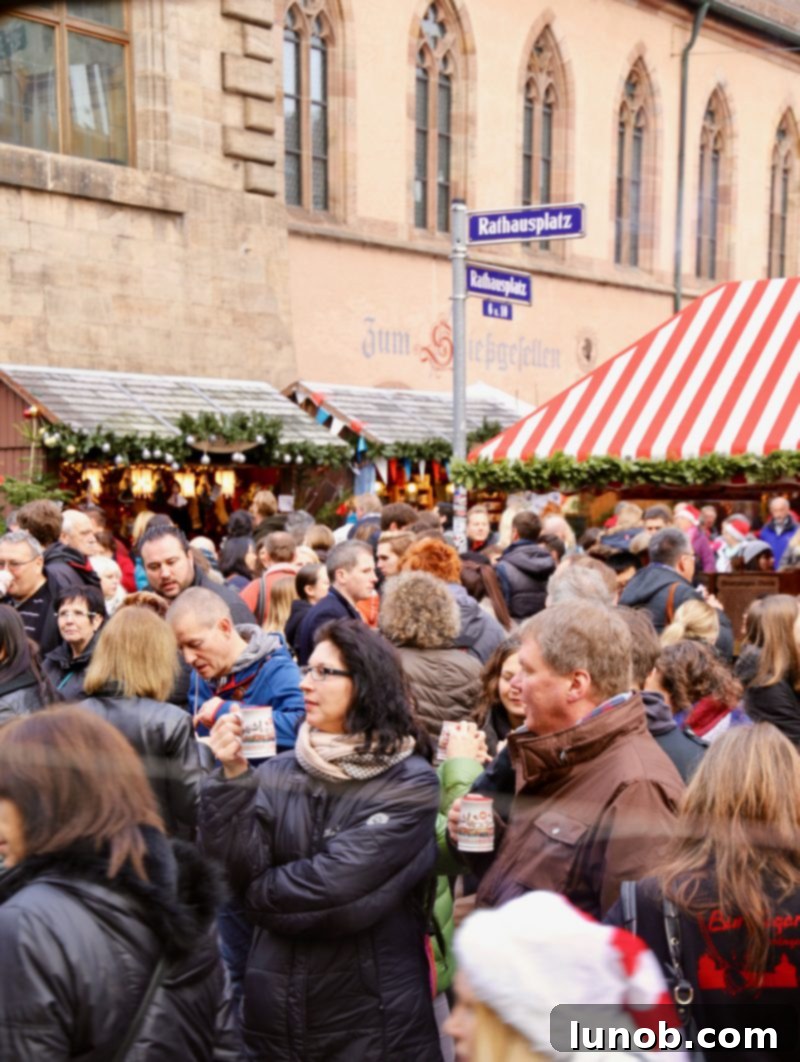 Gluhwein German Mulled Wine Munich Nuremberg Tradition 7 Crowds gathered around Christmas market stalls enjoying hot Glühwein in Germany