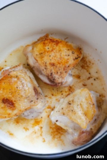Homemade Restaurant-Style Chicken Scarpariello Perfection 4 Seared chicken thighs with golden brown skin in a Dutch oven