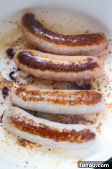 Homemade Restaurant-Style Chicken Scarpariello Perfection 5 Seared Italian sausage links in a Dutch oven, browned on all sides