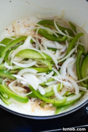 Homemade Restaurant-Style Chicken Scarpariello Perfection 6 Sautéing sliced green bell peppers and onions in a Dutch oven