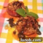 Broiled Chocolate Amaretti Peaches with a golden-brown cookie crumble topping and chocolate drizzle.