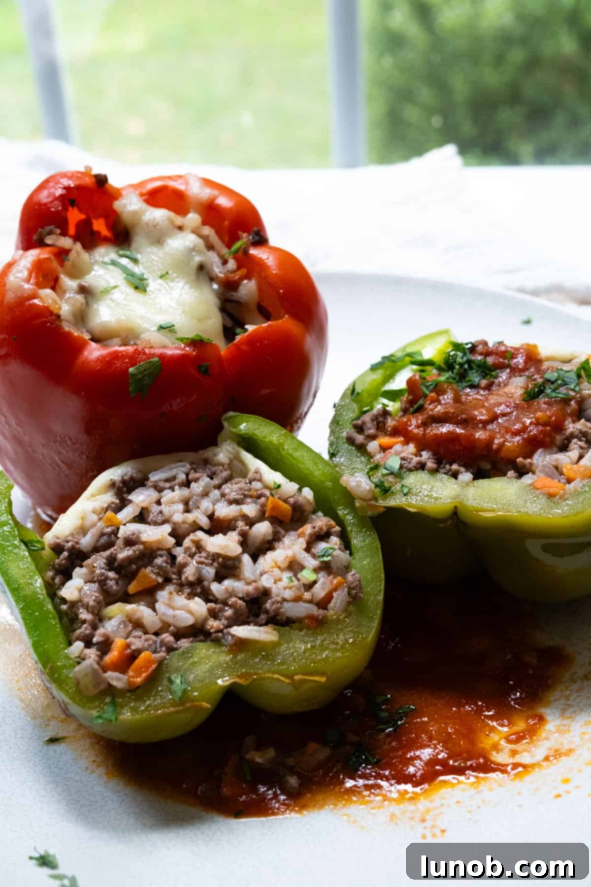 Italian stuffed peppers topped with melted mozzarella cheese and rich tomato sauce, ready to serve.