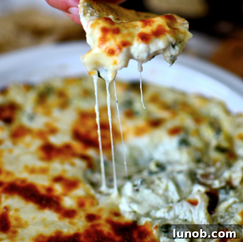 Winning Game Day Eats For Every Fan 6 Warm and bubbly cheesy asiago, artichoke, and spinach dip with bread for dipping.