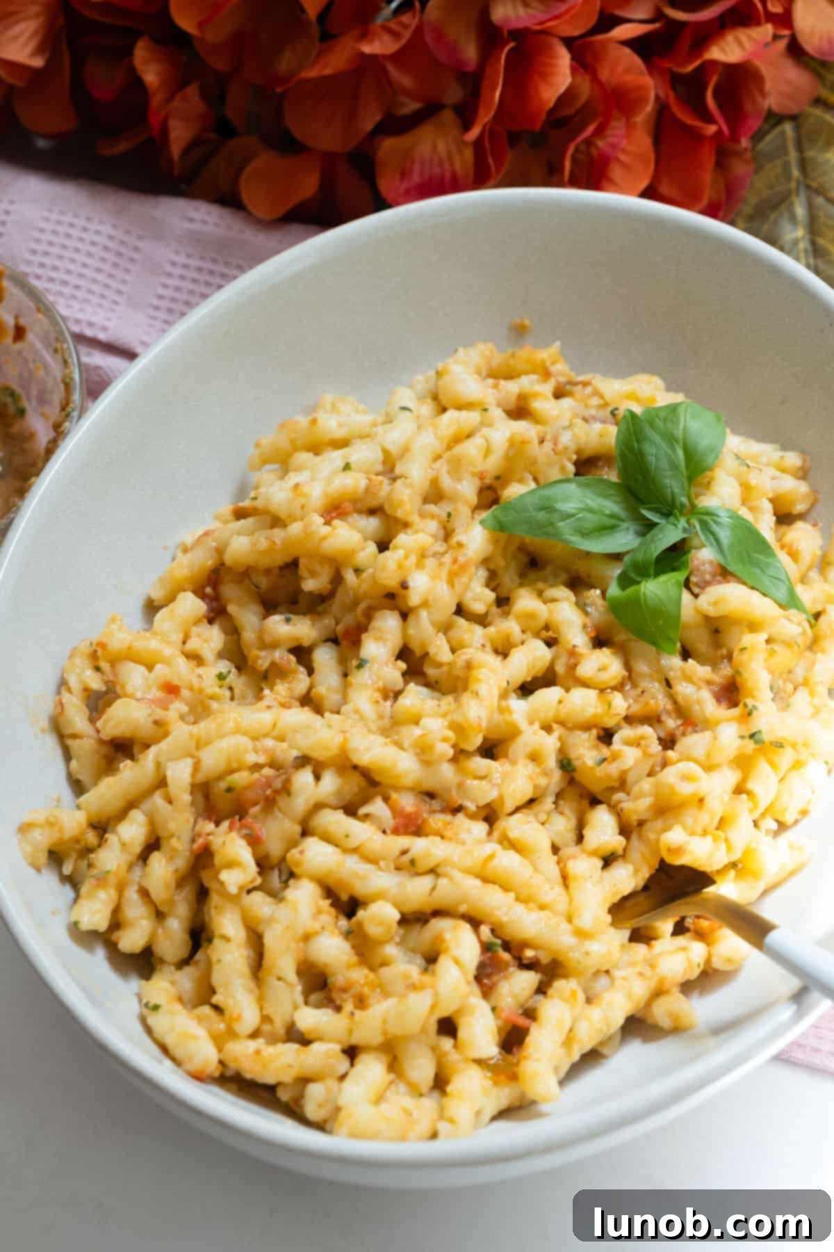 Sicilian Sun-Kissed Busiate 9 Busiate with pesto alla trapanese, garnished with fresh basil and parmesan, ready to serve.