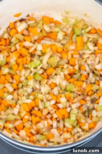 Chopped carrots, onions, and celery sautéing in the Dutch oven.