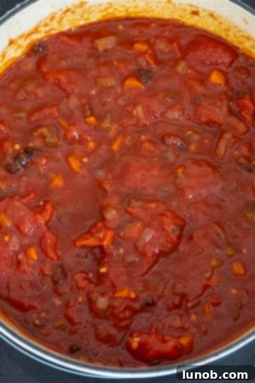 Tomato sauce simmering gently in the Dutch oven.