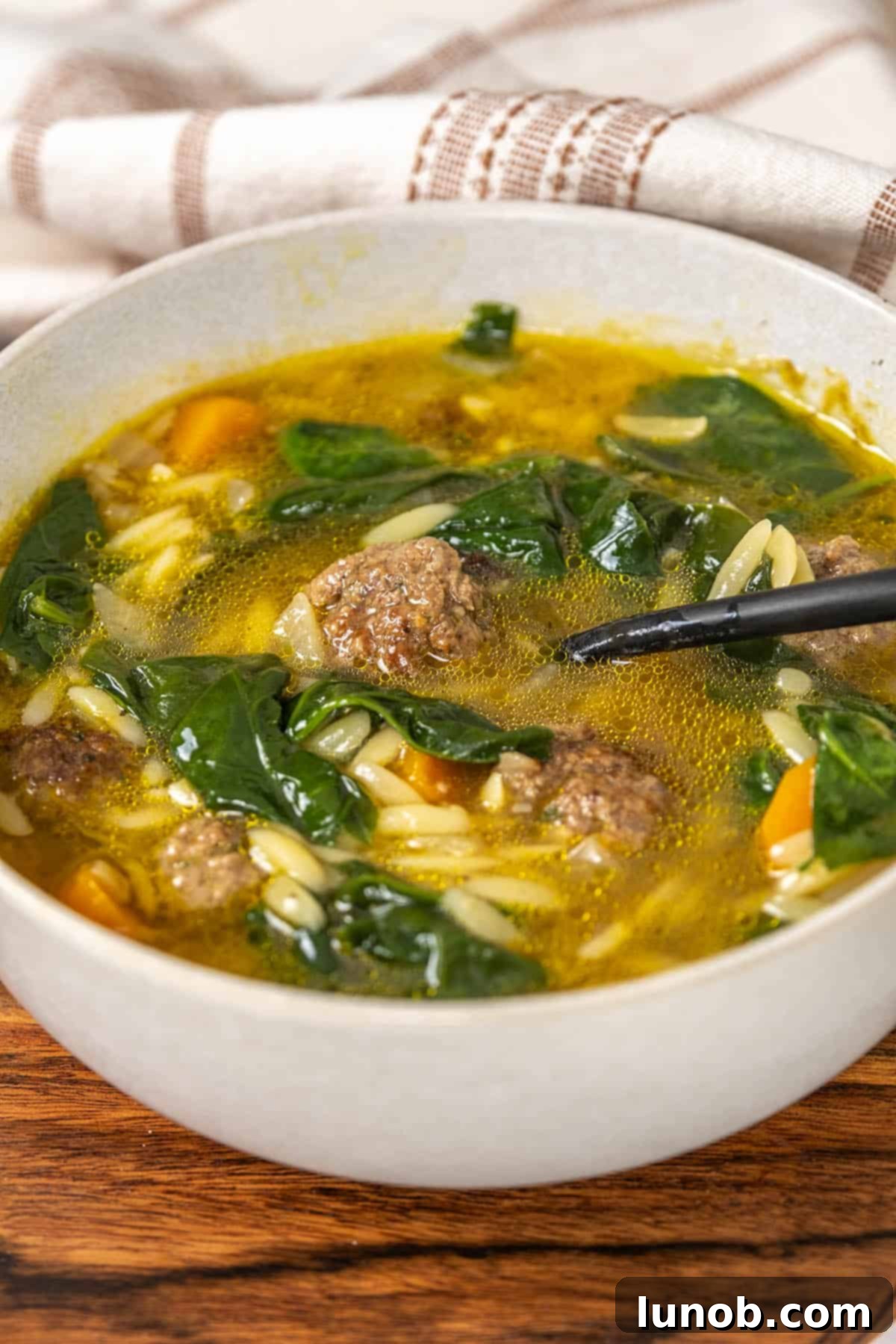 Rustic Italian Meatball & Escarole Soup 2 A delicious bowl of homemade Italian wedding soup with tender beef meatballs, orzo pasta, and fresh spinach.