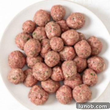 Rustic Italian Meatball & Escarole Soup 4 Small, perfectly rolled Italian beef meatballs on a cutting board, ready for frying.