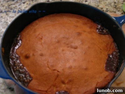 A close-up of the Pineapple Upside-Down Cake baking in a pan, showing the batter over the pineapple layer.