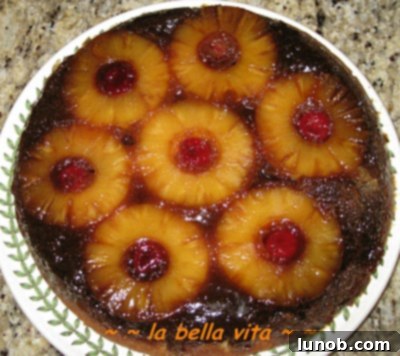 A final, mouth-watering image of a whole Pineapple Upside-Down Cake, perfectly golden and ready to be sliced.