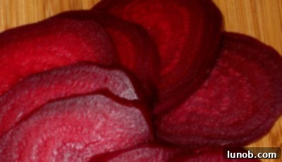 Close-up of a perfectly cooked and sliced beet, showing its rich, deep red color and tender texture
