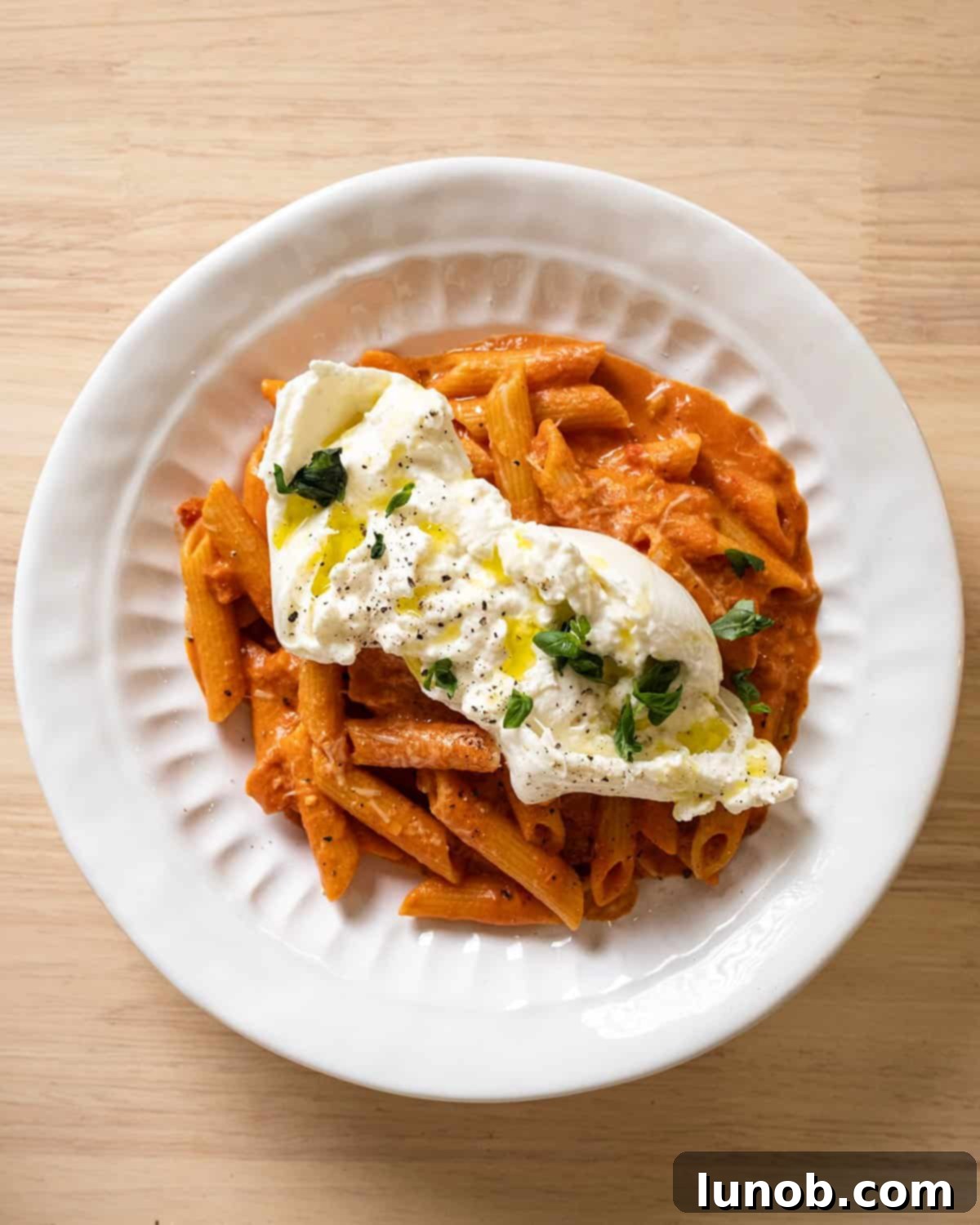 Fiery Vodka Pasta 9 Penne alla vodka topped with a luscious ball of burrata cheese and fresh basil.