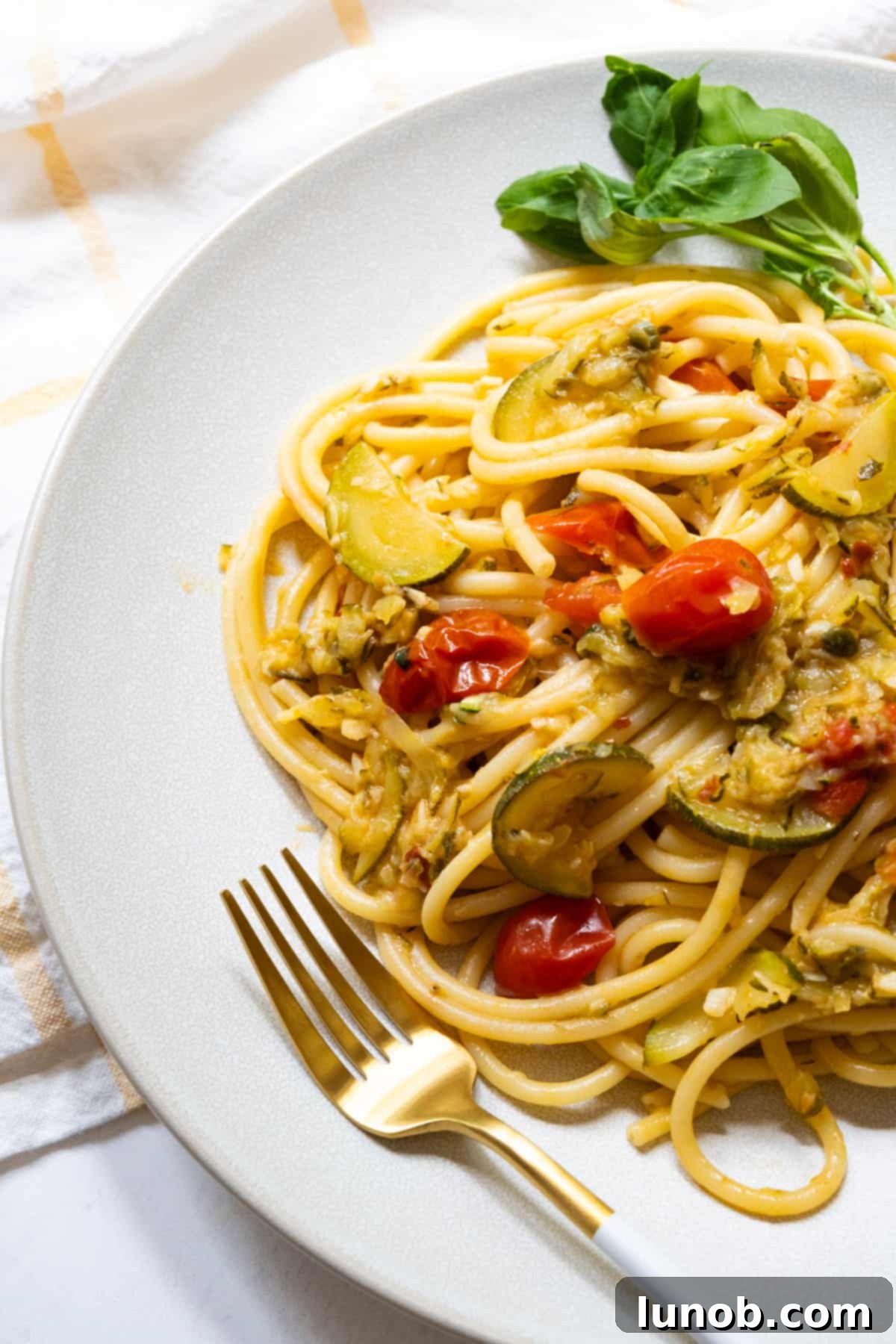 Finished Italian Summer Pasta with Zucchini and cherry tomatoes, beautifully plated and garnished.