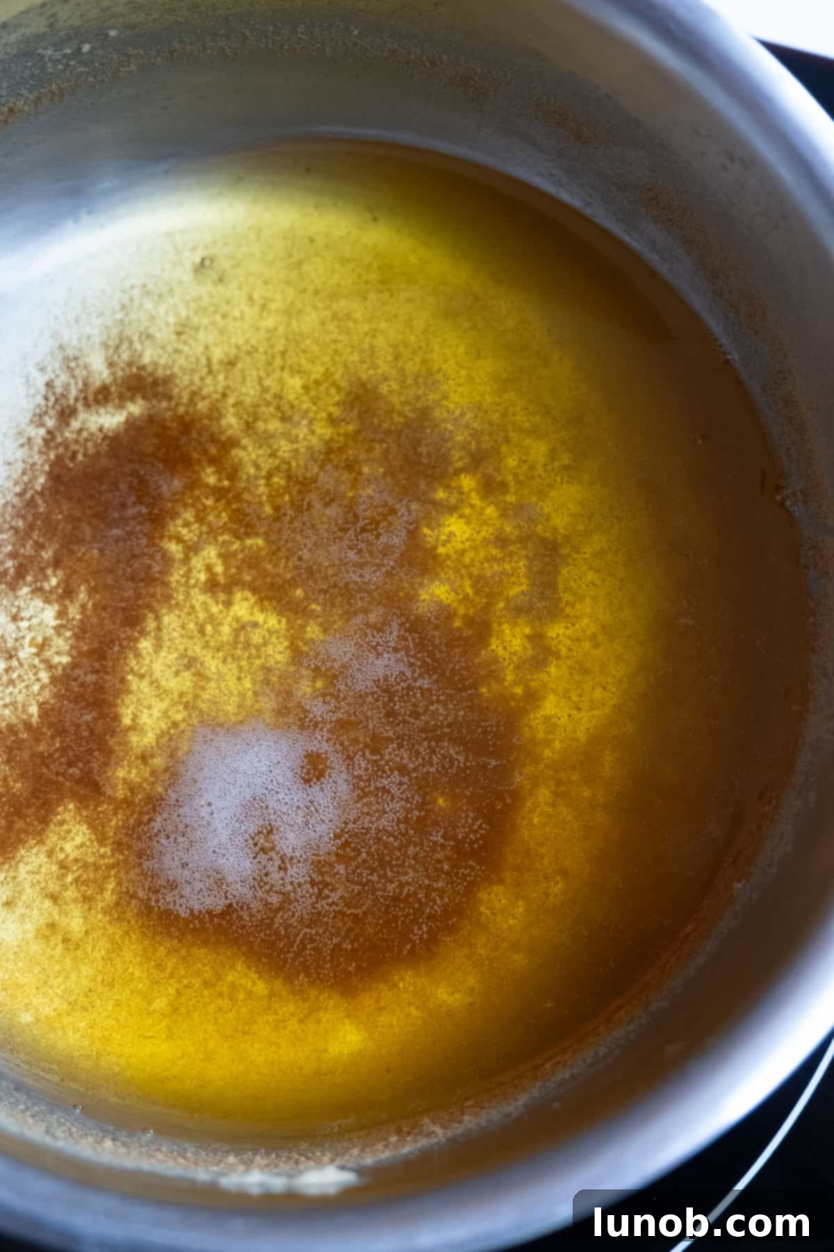 browned butter in a small saucepan, showing golden brown milk solids at the bottom