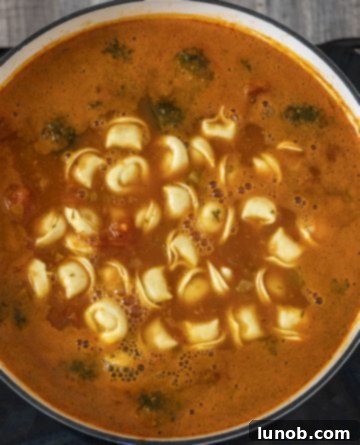 Cheese tortellini added to the simmering Italian sausage and vegetable soup
