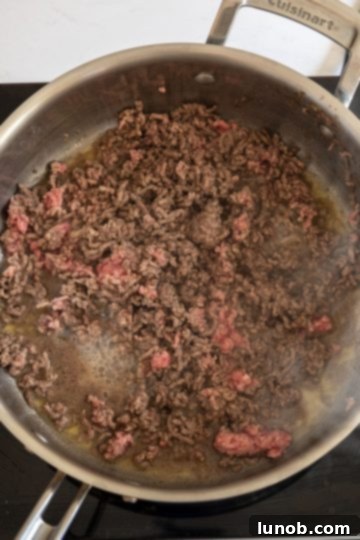 Cooked ground beef with no pink remaining, ready to be removed from the pan.