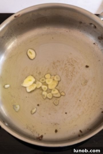Minced garlic sautéing in olive oil in the saucepan.