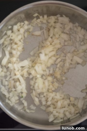 Sauteed onions shimmering in olive oil in a saucepan