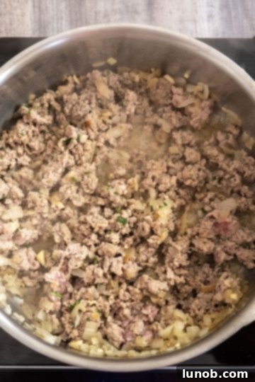 Perfectly browned sausage and onions in a saucepan