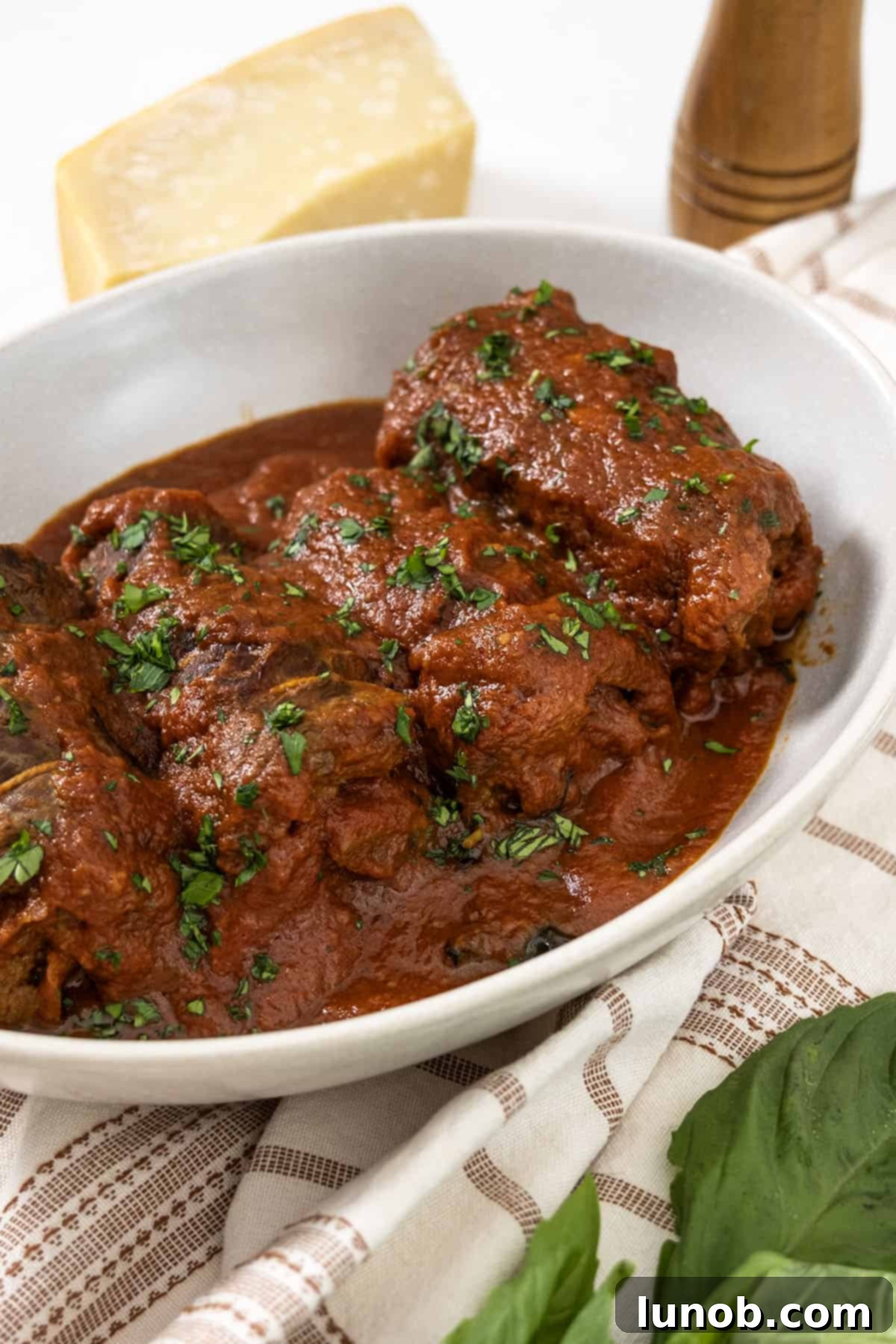 Italian braciole garnished with fresh parsley and served with Sunday Sauce