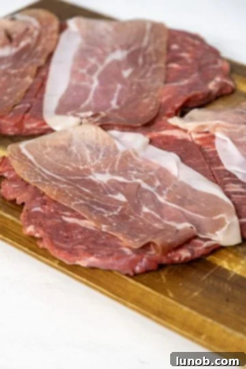 Flank steaks topped with prosciutto slices