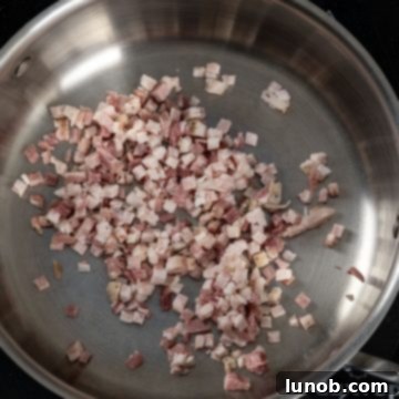 Pancetta pieces spread on a cold pan, ready for cooking