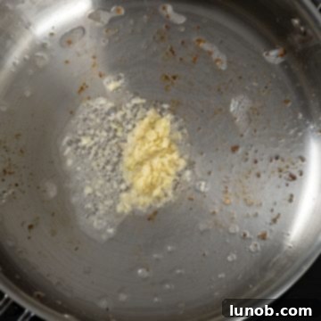 Minced garlic sizzling in a pan with olive oil