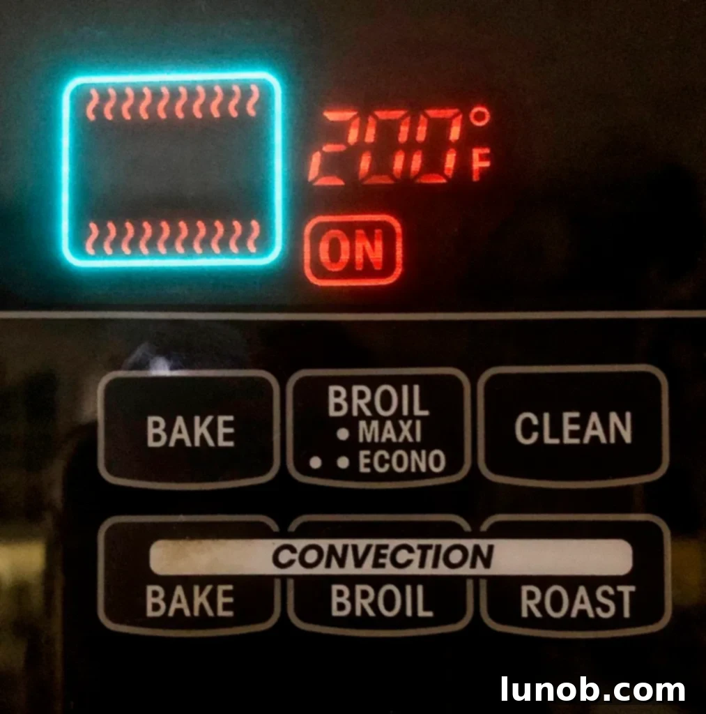 Cheesecake Perfection 17 Adjusting the oven temperature down to 200 degrees Fahrenheit.