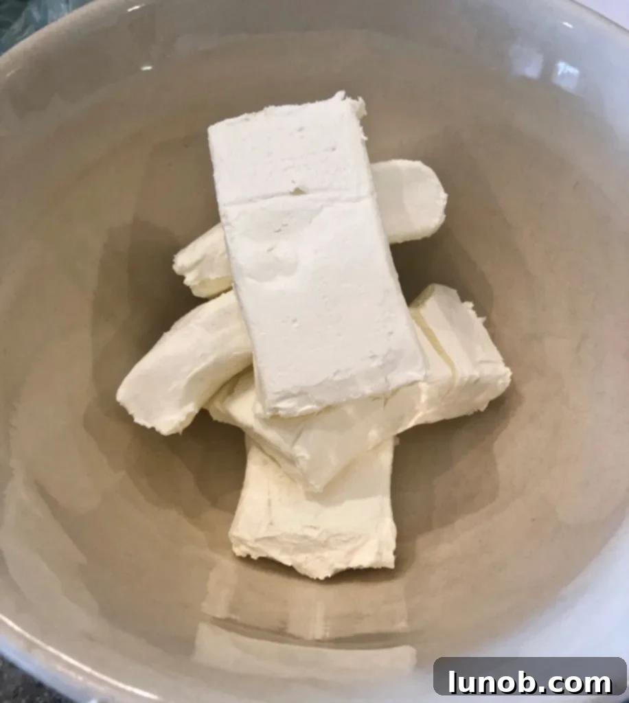 Cheesecake Perfection 6 Five packages of cream cheese in a large mixing bowl.