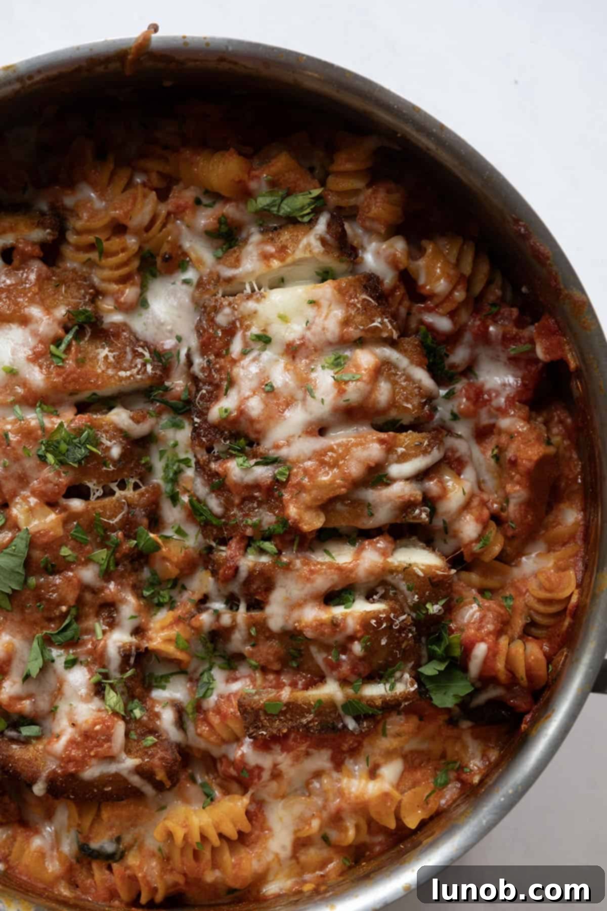 Velvety Chicken Parmesan Pasta 2 creamy chicken parmesan pasta in a skillet