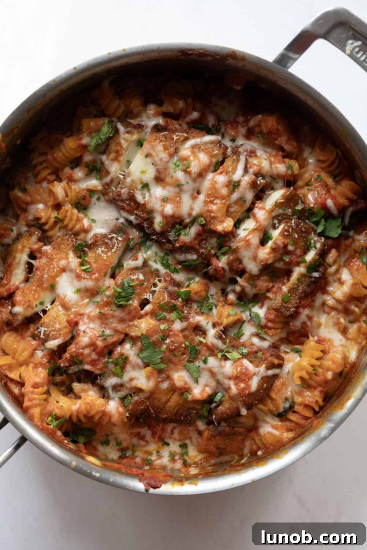 Velvety Chicken Parmesan Pasta 9 creamy chicken parmesan pasta in a skillet