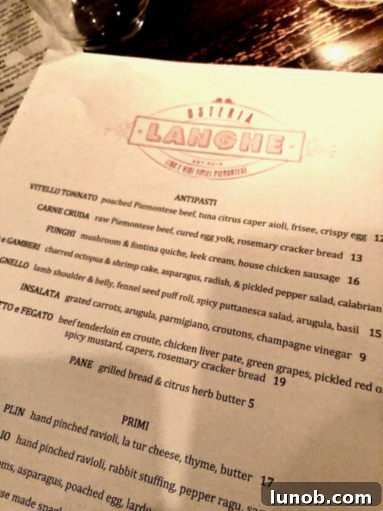 Close-up of the Vitello Tonnato dish at Osteria Langhe, featuring delicate slices of veal topped with a creamy tuna and caper aioli, garnished beautifully.