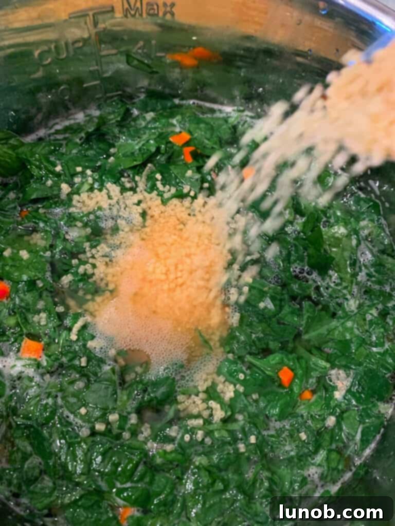 Whisking fresh jumbo eggs with grated Parmigiano cheese for the traditional Italian Wedding Soup finish, adding creaminess and depth.