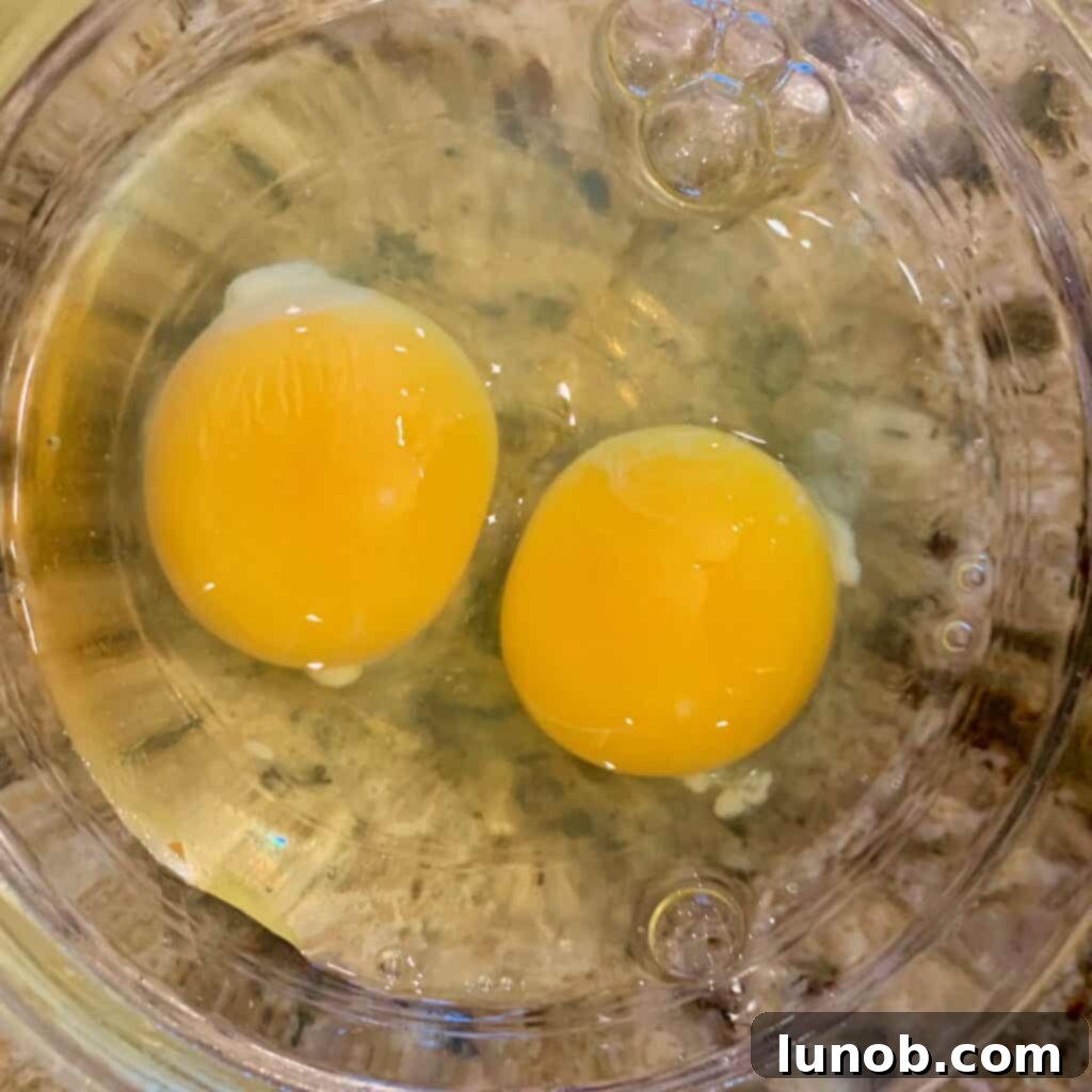Gently swirling the egg and Parmigiano cheese mixture into the hot Italian Wedding Soup, creating delicate, flavorful strands.